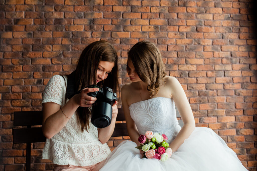 Wedding photographer showing the bride wedding photos